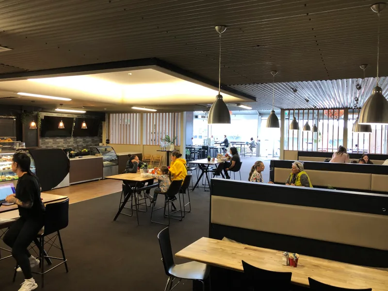 Seating, pendant lights and customers inside Cafe Jireh